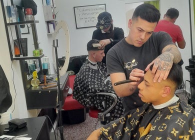 Barbero en Apuro Fade, Billinghurst, Provincia De Buenos Aires, AR, realizando un corte de pelo preciso.