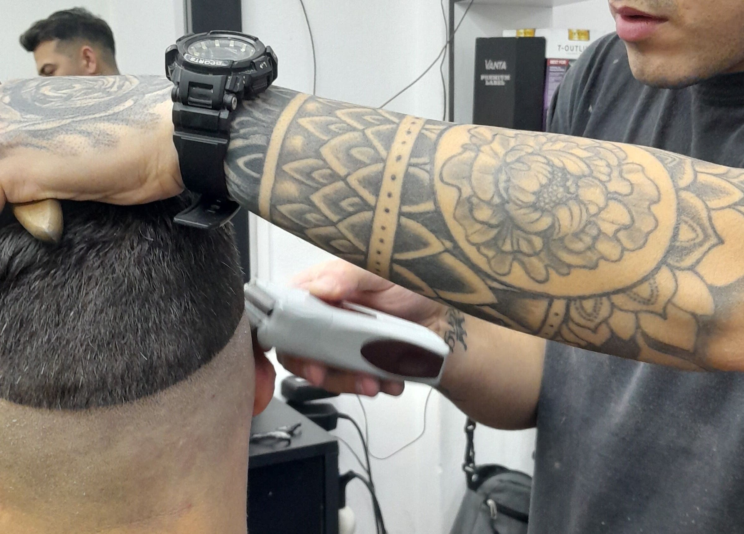 Tatuado estilista realizando corte fade en Apuro Fade, Billinghurst, Provincia De Buenos Aires, AR.