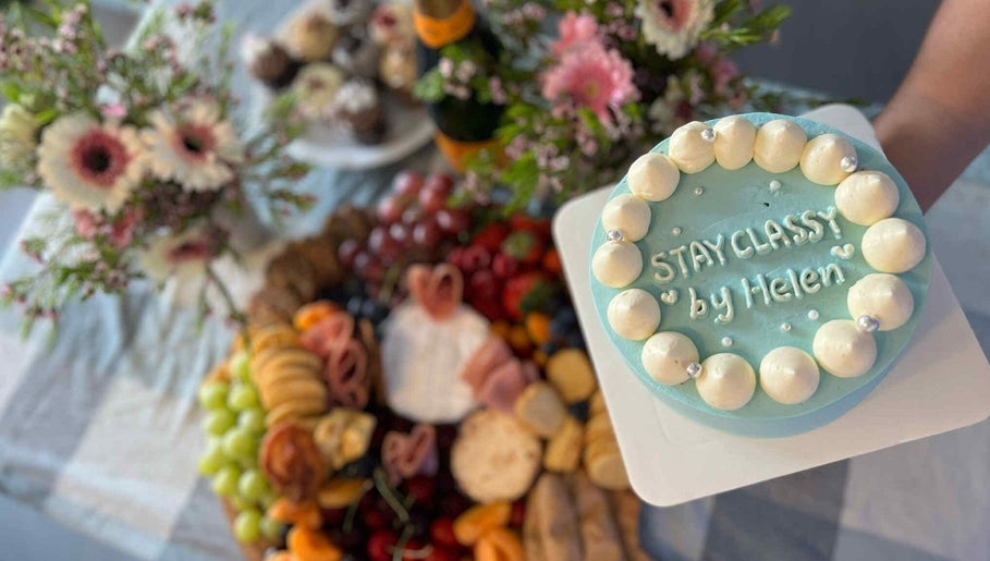Elegant cake with 'Stay Classy By Helen' design at Sydney, New South Wales, AU venue, surrounded by floral decor.