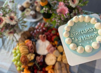 Elegant cake with 'Stay Classy By Helen' design at Sydney, New South Wales, AU venue, surrounded by floral decor.