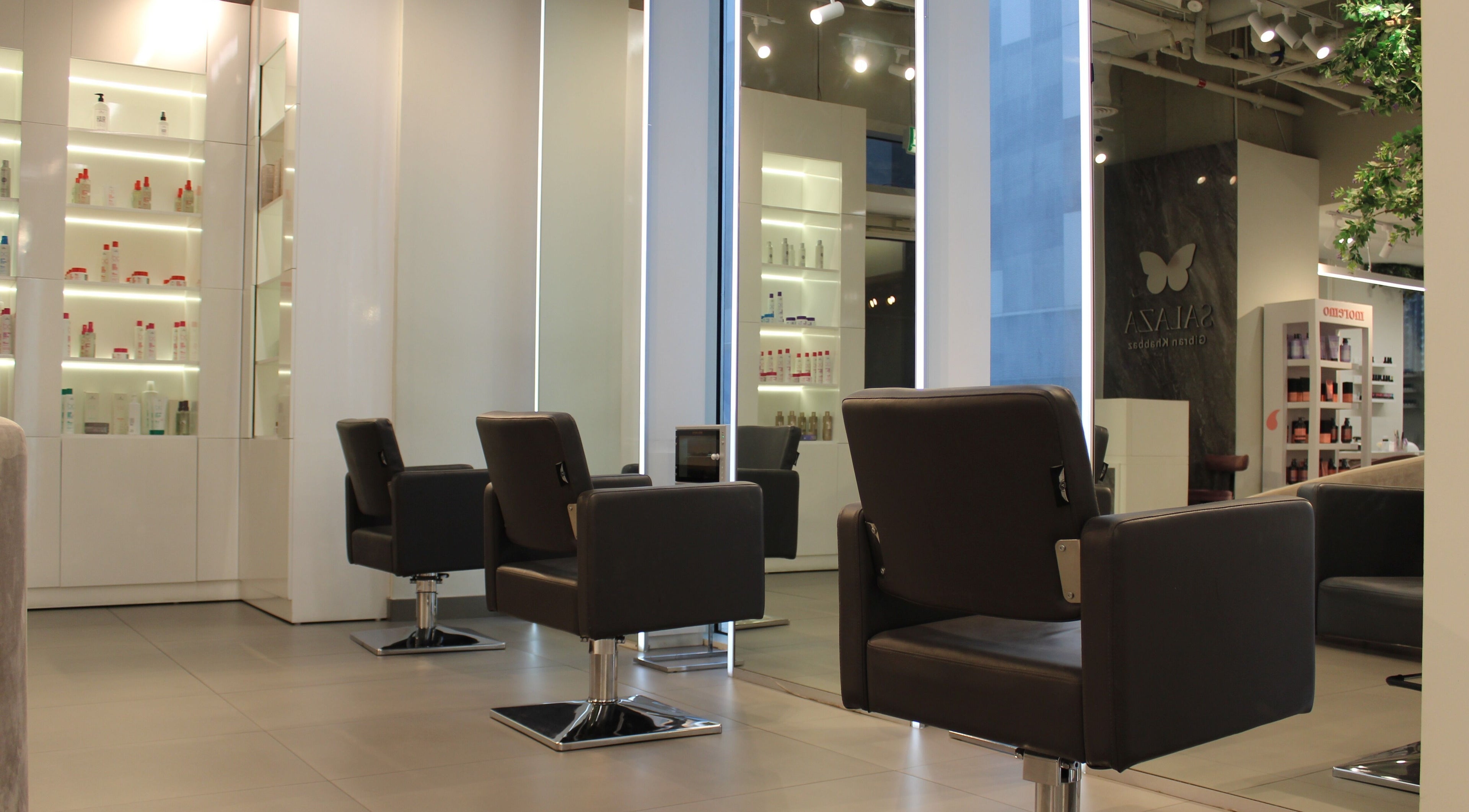 Modern salon interior at Salaza Gibran Khabbaz, Dubai, Dubai, AE showcasing sleek styling chairs and product displays.