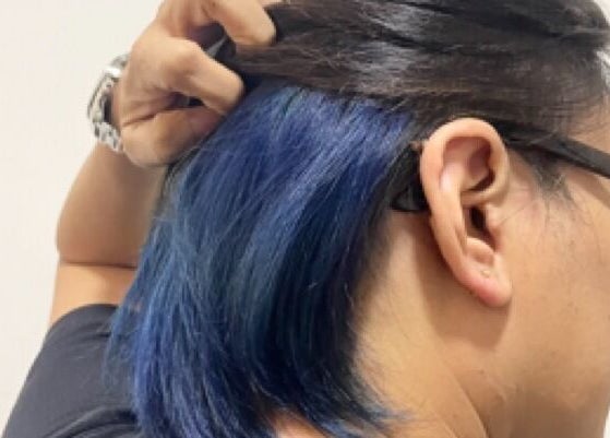 Blue hair highlight at HairByIsk Studio, Singapore, Singapore, SG, showing unique color under dark hair.