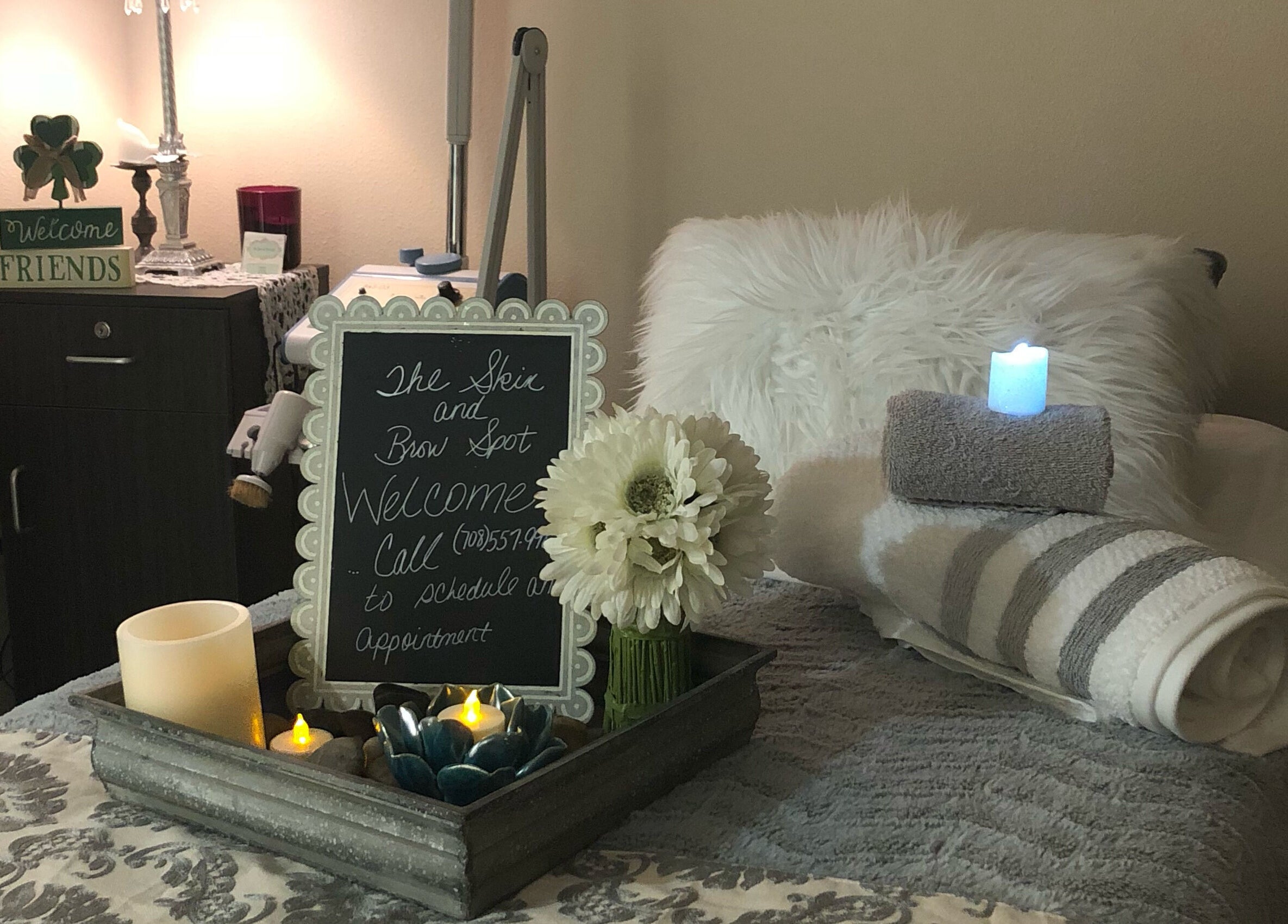 Relaxing spa setup at The Skin and Brow Spot, Countryside, Illinois, US with candles and a welcome sign.
