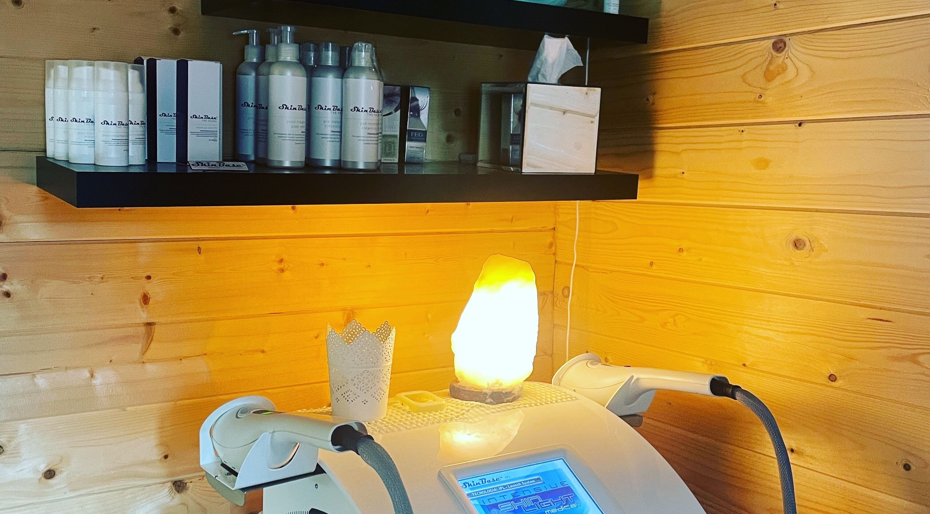 Cozy setting with skincare in Sarahs Beauty Therapy, Poole, England, GB, wooden walls and warm lamp glow.