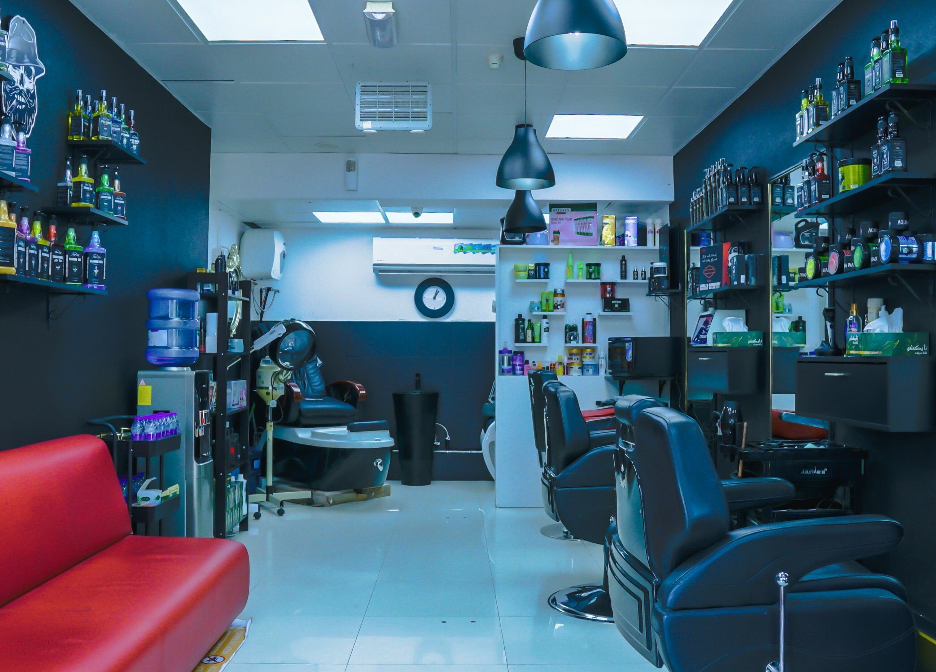 Modern interior of Fadez Gents Salon in Dubai, AE, featuring sleek chairs and product shelves.