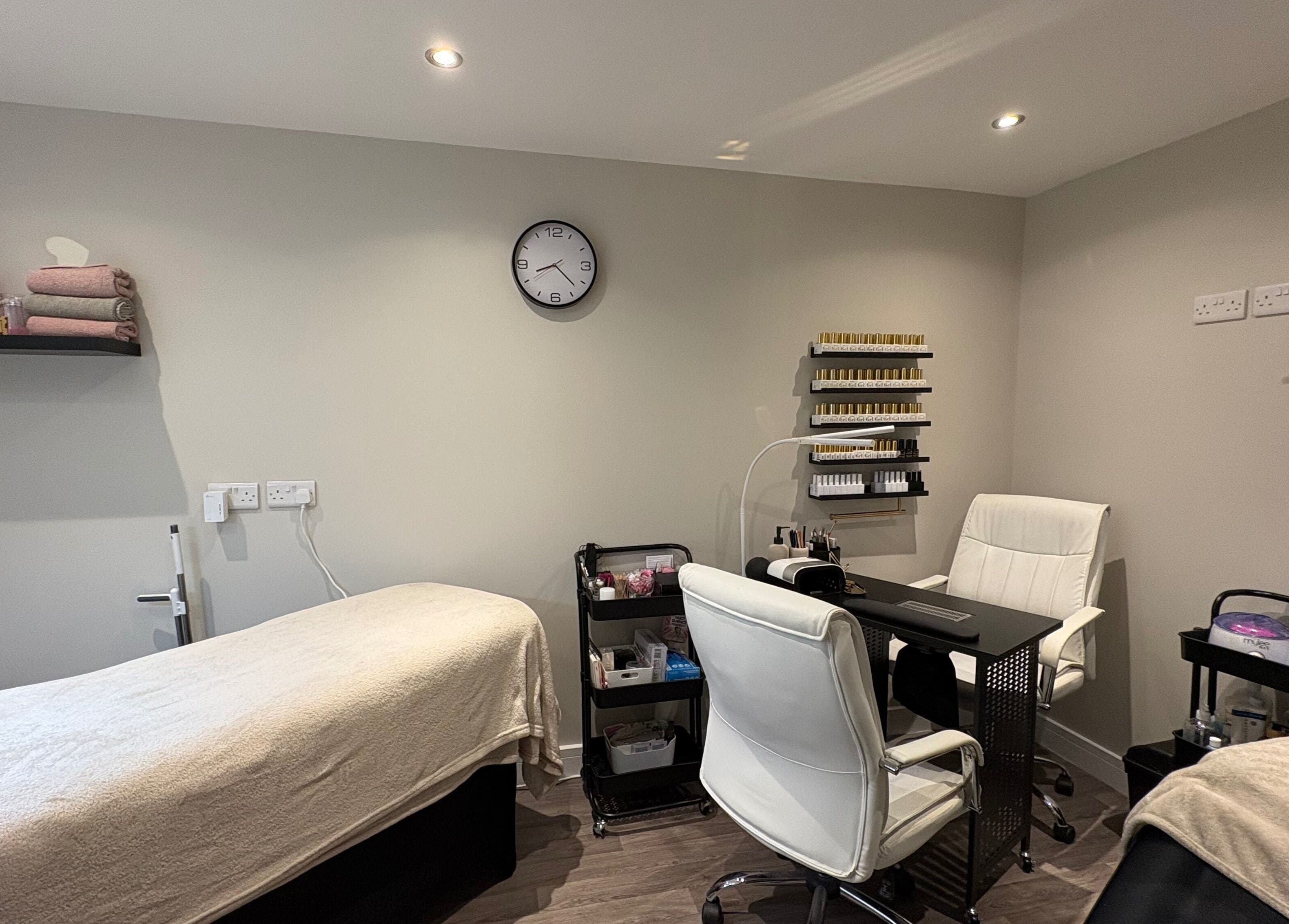 Pretty Beautiful's cozy treatment room in Waterlooville, England, GB, featuring a massage bed and nail station.