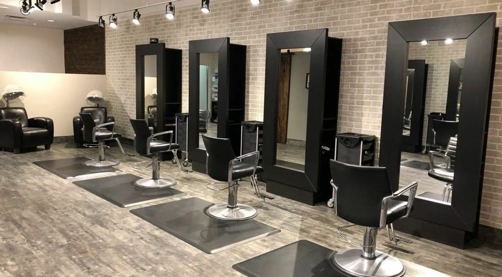 Modern salon stations at Hair Tec Salon in Calgary, Alberta, CA with sleek black chairs and mirrors.