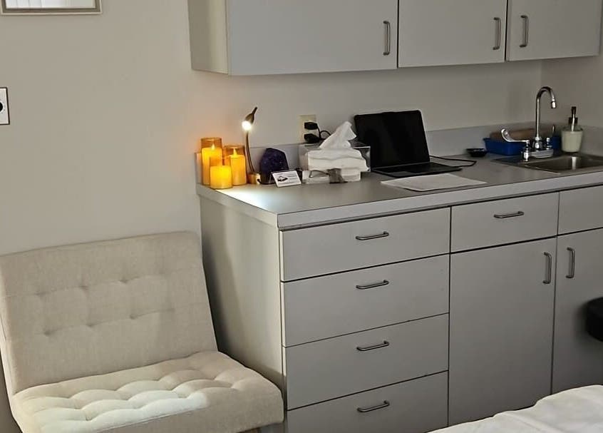 Cozy treatment room at Legend Wellness Center - Yonkers, featuring candles and a white chair in Yonkers, New York, US.