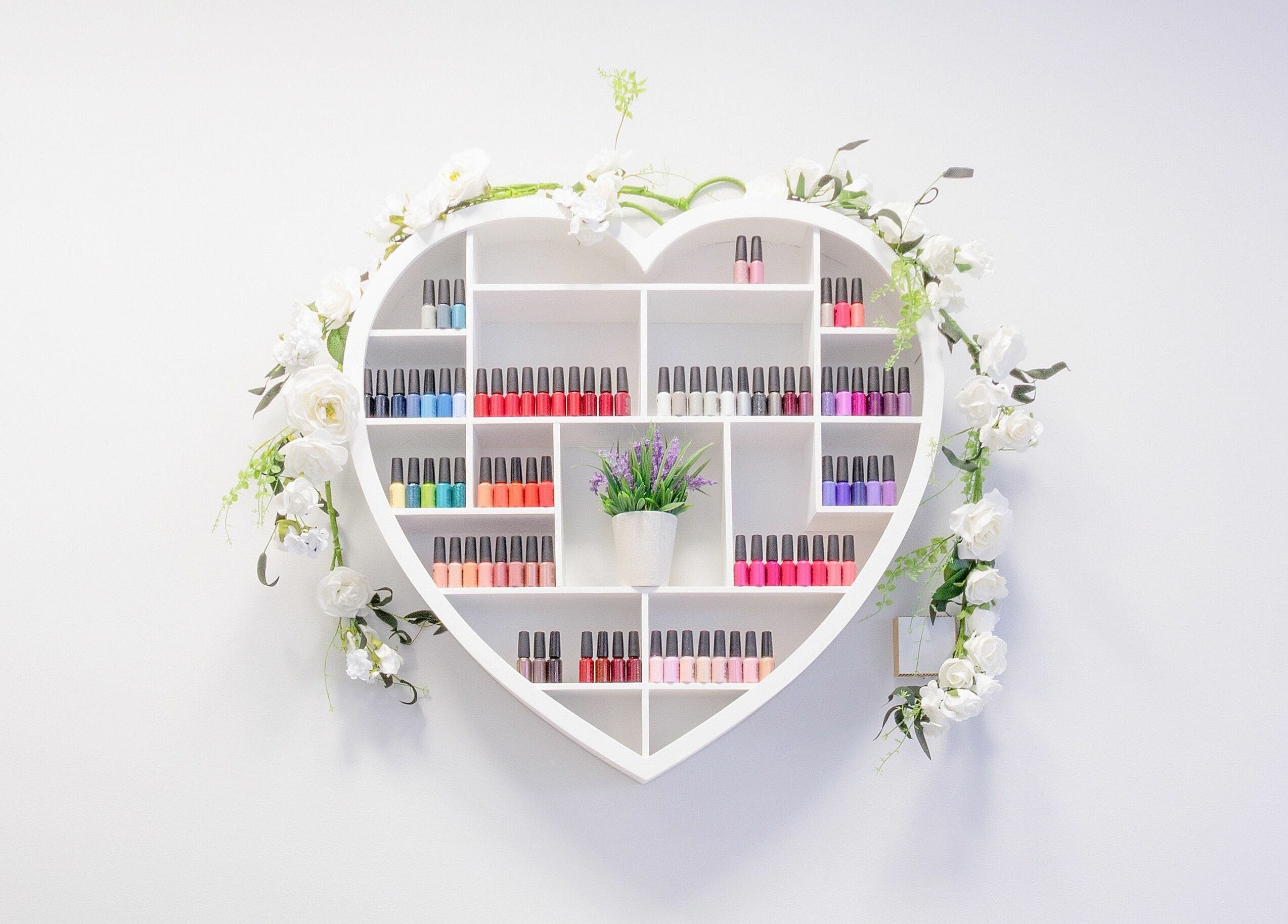 Heart-shaped nail polish display with floral decor at Forever Beautiful, Wooler, England, GB.