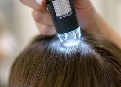 Scalp analysis at Beauty By Marina in Thetford, England, GB, using a lighted magnifier for hair health.
