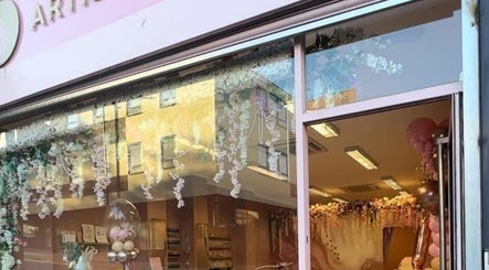 Exterior view of Artistry Clinic in Rotherham, England showcasing elegant decor and floral displays.
