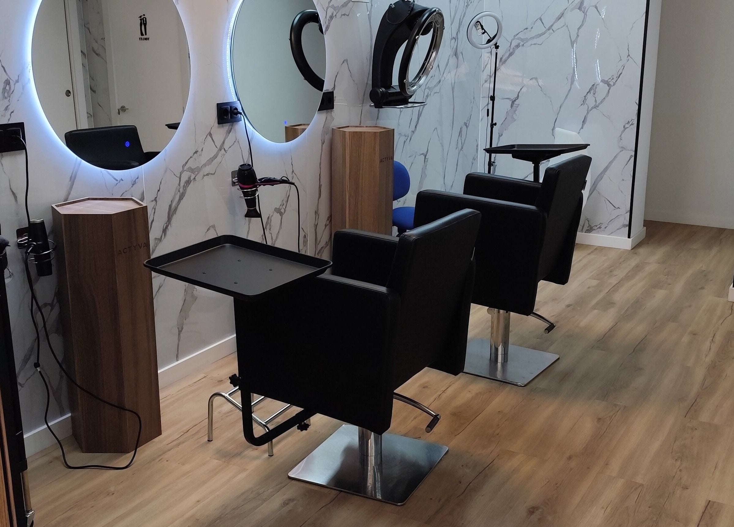 Interior moderno de Divinas Look Pelu en Paiporta, Comunidad Valenciana, ES, con sillas elegantes y espejos iluminados.