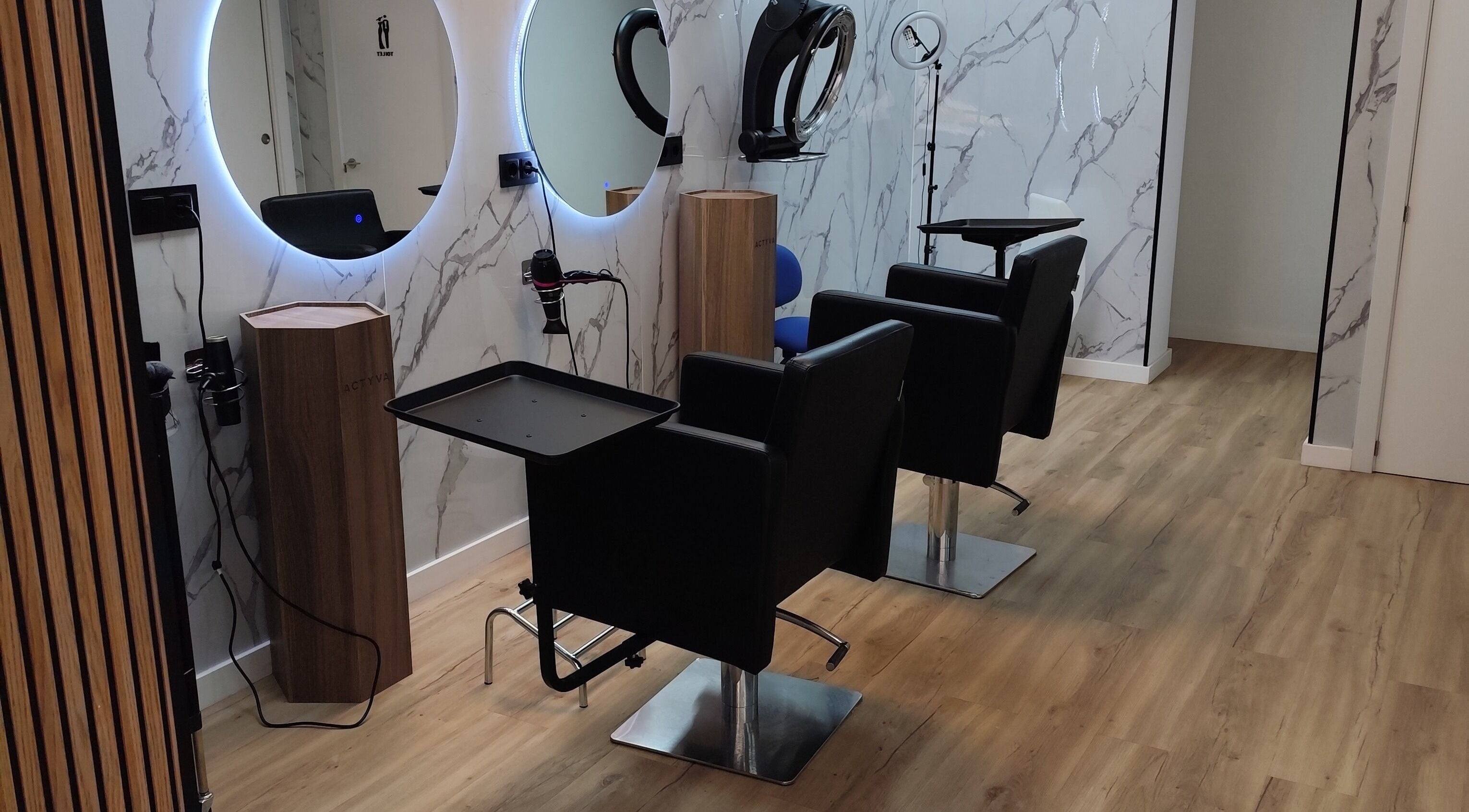 Interior moderno de Divinas Look Pelu en Paiporta, Comunidad Valenciana, ES, con sillas elegantes y espejos iluminados.