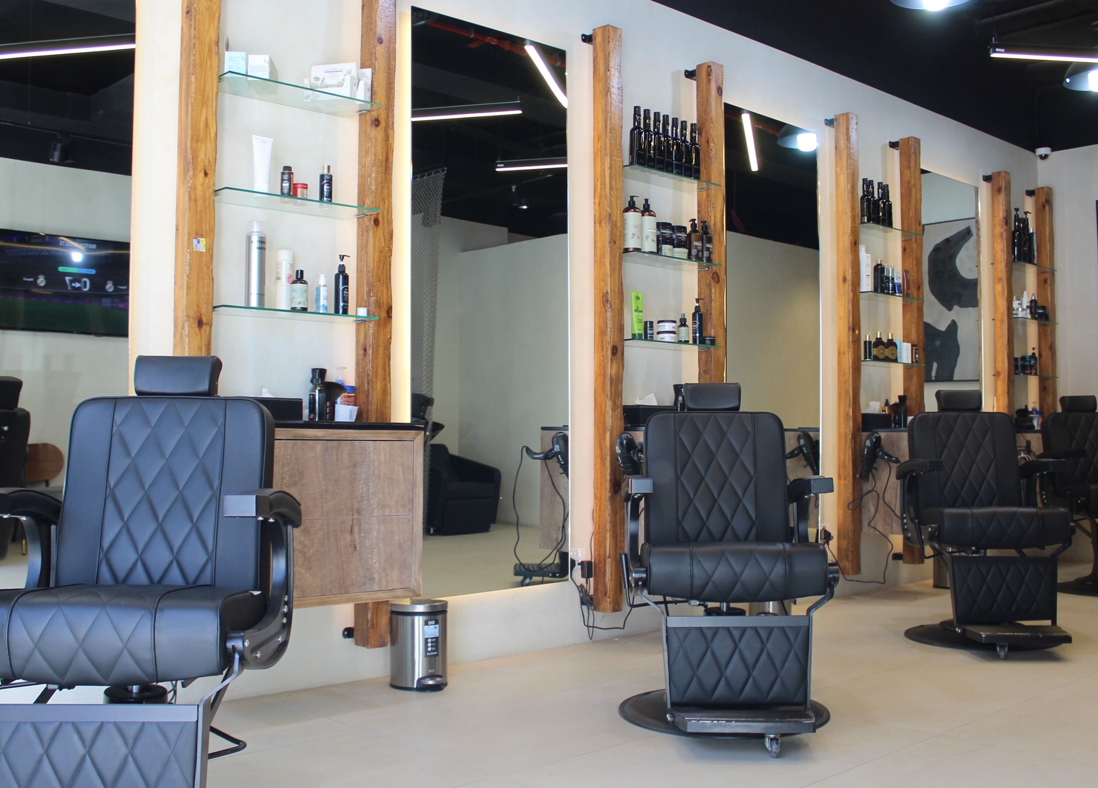 Stylish salon interior at Hairmess, Dubai, Dubai, AE with modern black chairs and wood accents.