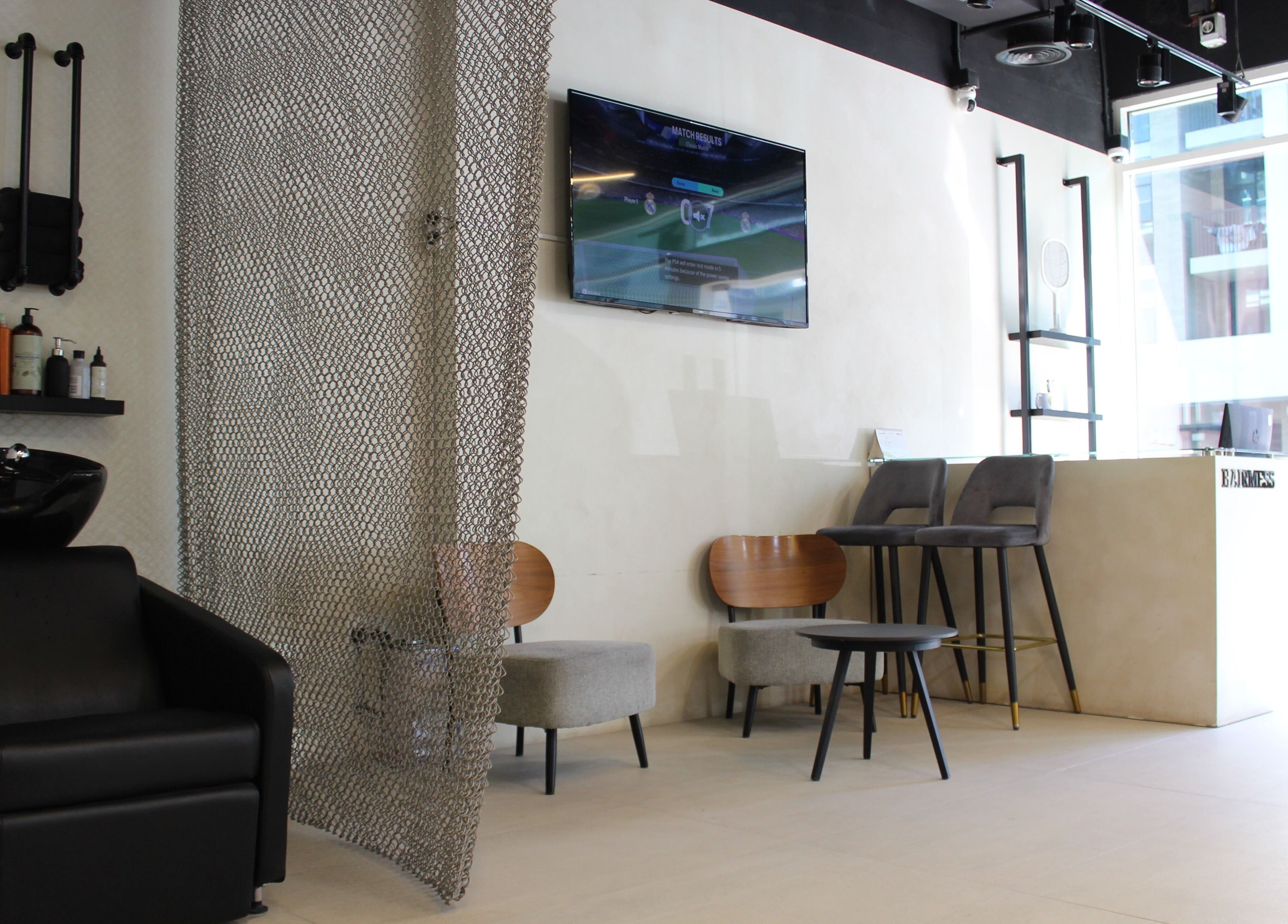 Elegant salon interior at Hairmess, Dubai, Dubai, AE featuring seating and a wash station.
