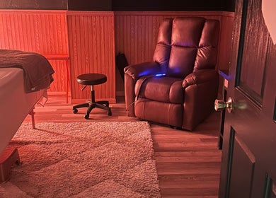 Relaxing massage room at The Body Shoppe in Darlington, Wisconsin, US, featuring a plush chair and soothing decor.