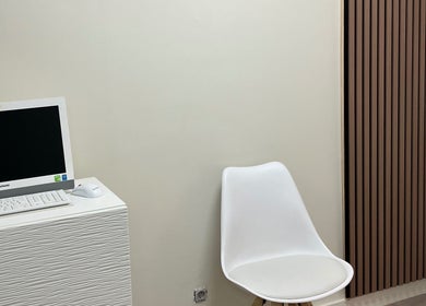 Sala de espera minimalista en REvive Salud, Majadahonda, Comunidad De Madrid, ES, con silla blanca y monitor.