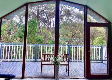 Serene deck view from Wandong Wellness Retreat in Wandong, Victoria, AU overlooking lush forest scenery.