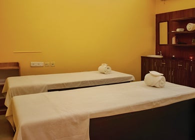 Relaxing massage room at Elanza de Look Unisex Salon & Spa in Bogmalo, Goa, IN featuring two treatment tables.
