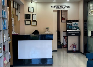 Reception area of Elanza de Look Unisex Salon & Spa in Bogmalo, Goa, IN featuring sleek decor and products.