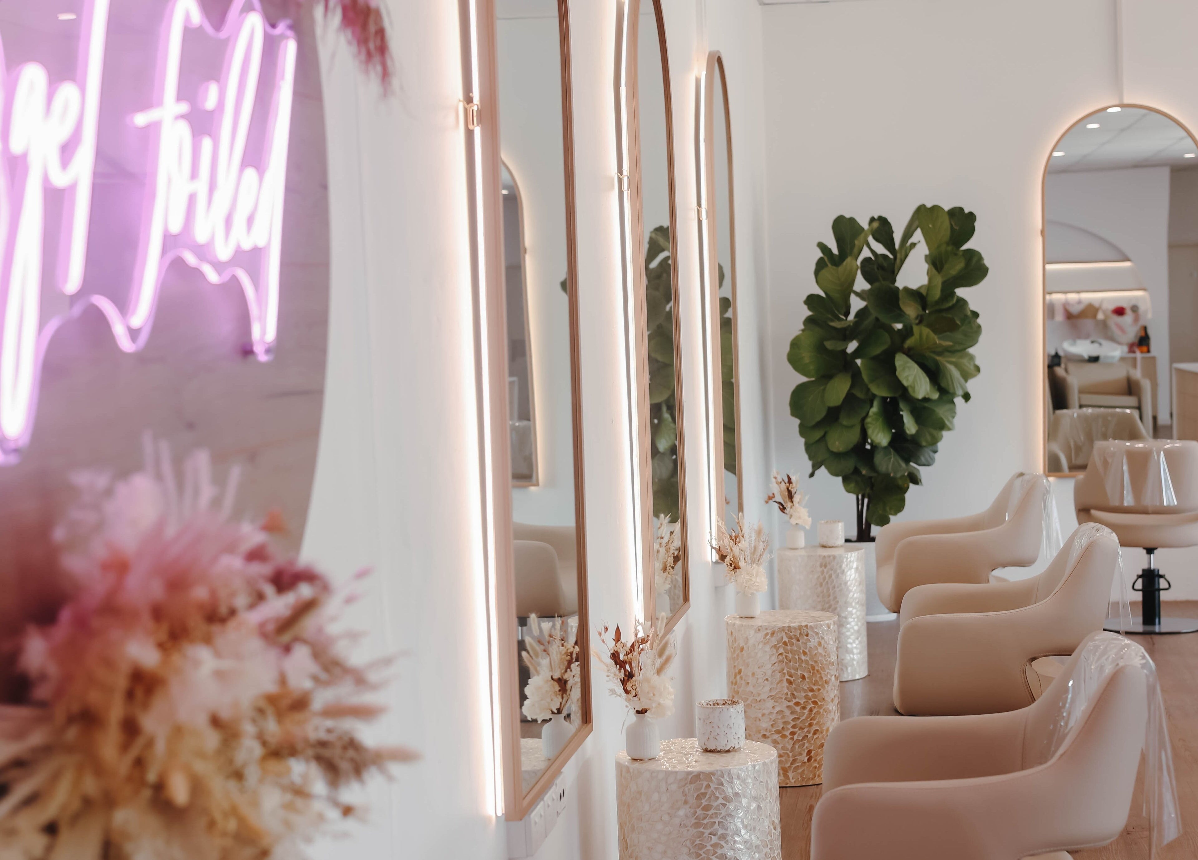 Stylish interior of Hair and the Fiddle, Narellan, New South Wales, AU, featuring elegant mirrors and plush chairs.