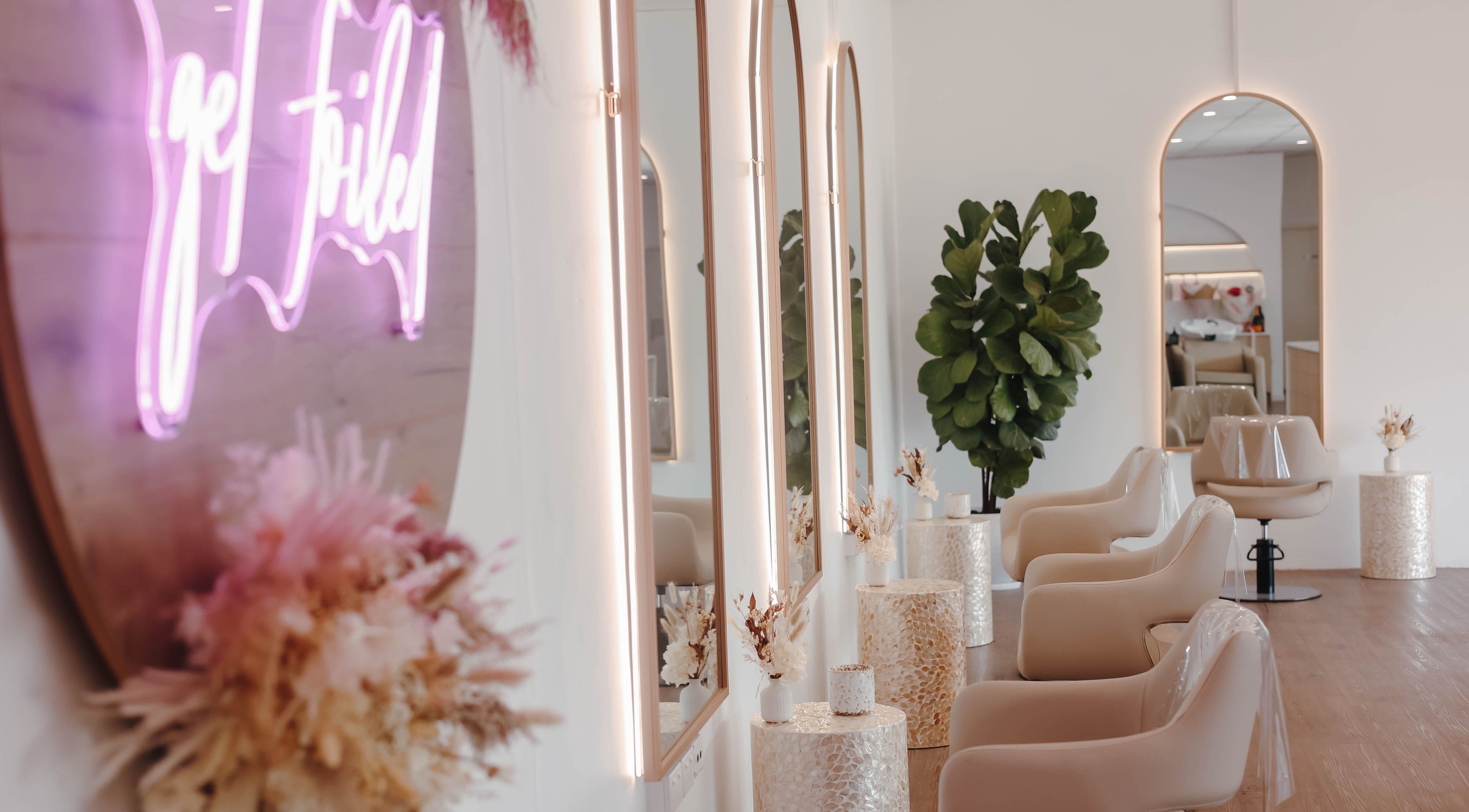 Stylish interior of Hair and the Fiddle, Narellan, New South Wales, AU, featuring elegant mirrors and plush chairs.
