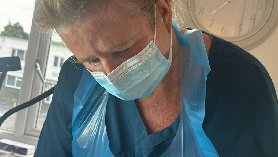 Professional at Ml Aesthetics in Birmingham, England, GB provides expert care wearing a mask and apron.