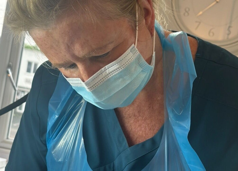 Professional at Ml Aesthetics in Birmingham, England, GB provides expert care wearing a mask and apron.