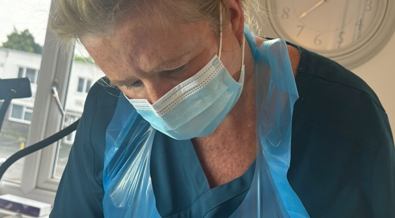 Professional at Ml Aesthetics in Birmingham, England, GB provides expert care wearing a mask and apron.