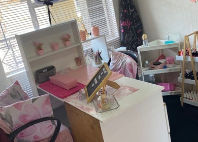 Cozy nail station at Nail and Art, Midrand, Gauteng, ZA with pink decor, shelves, and nail polish display.