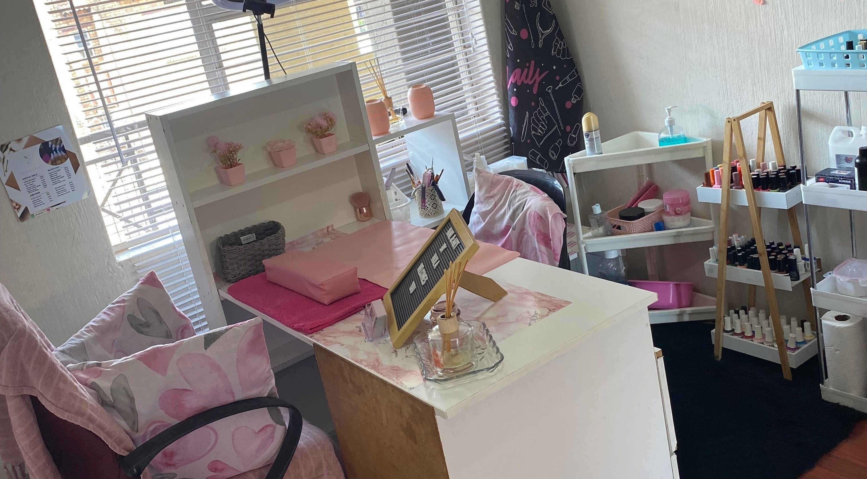 Cozy nail station at Nail and Art, Midrand, Gauteng, ZA with pink decor, shelves, and nail polish display.