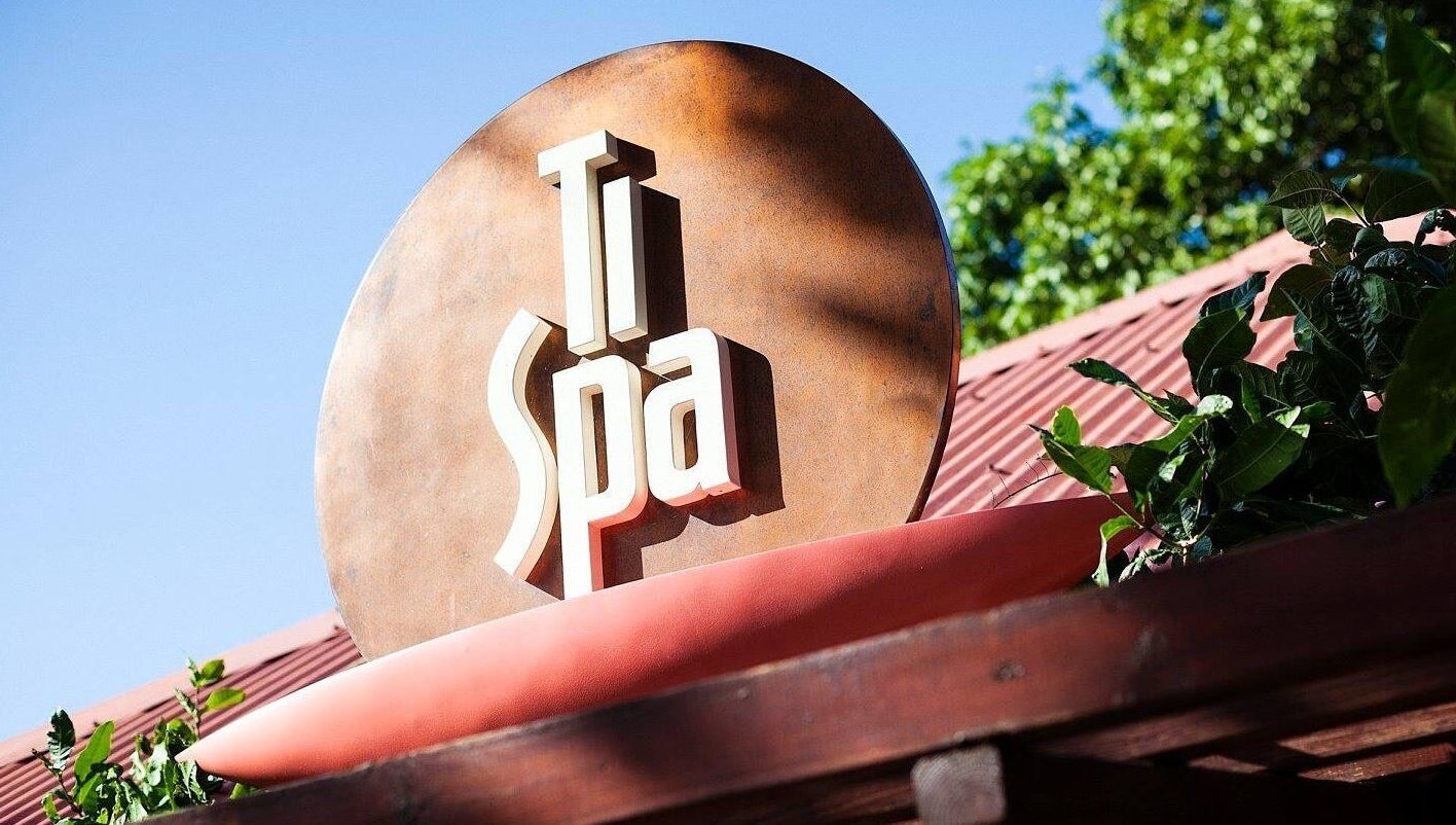 TI Spa's stylish outdoor sign at Grand Case, Saint-Martin, MF surrounded by lush greenery.