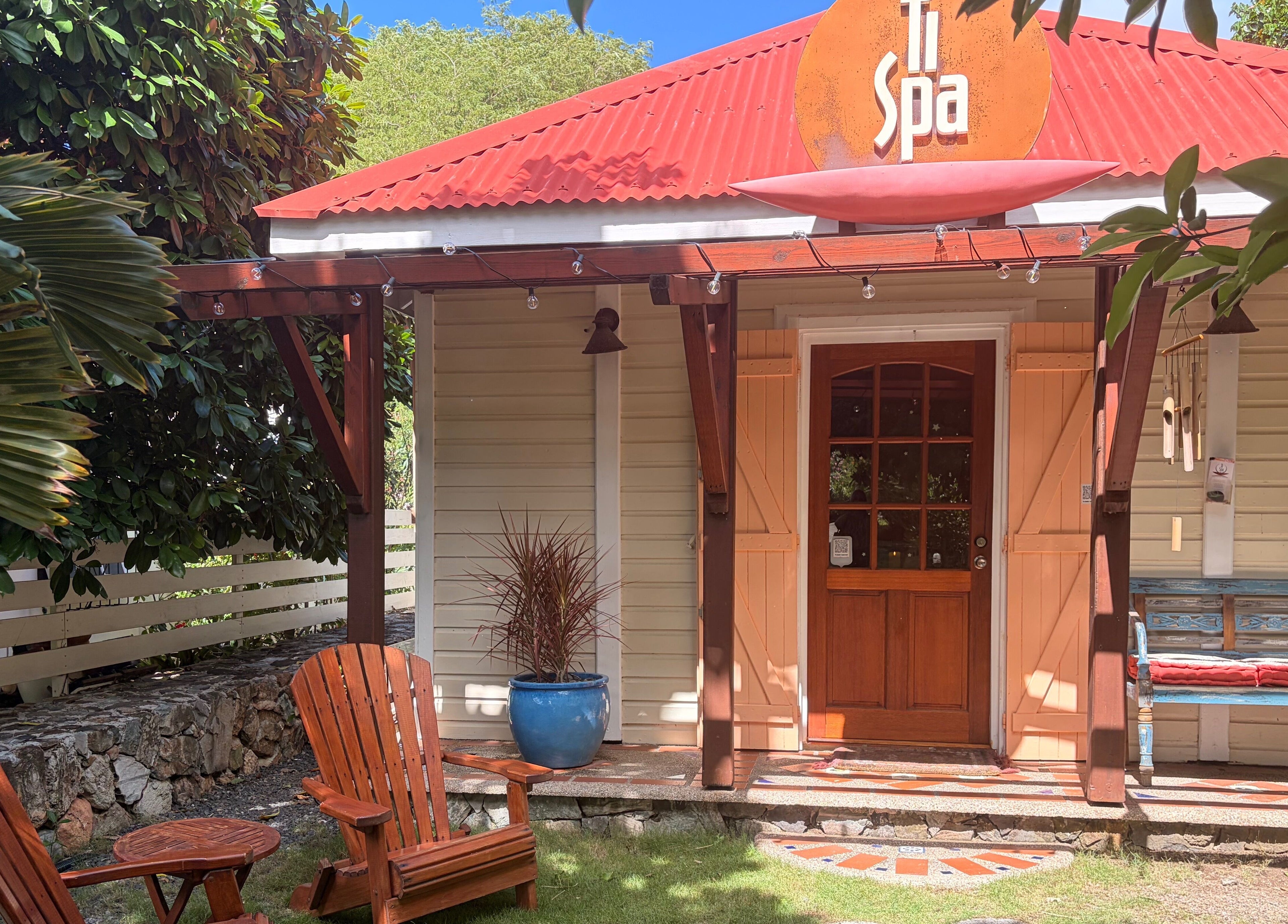 Charming entrance of TI Spa in Grand Case, Collectivité De Saint-martin, MF with wooden chairs and lush greenery.