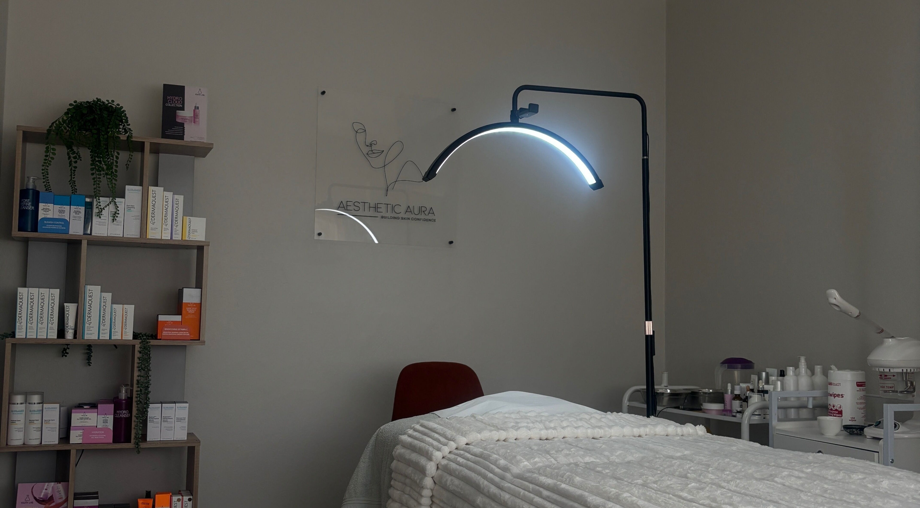 Serene treatment room at Aesthetic Aura, Randburg, Gauteng, ZA, showcasing a cozy bed and professional skincare products.