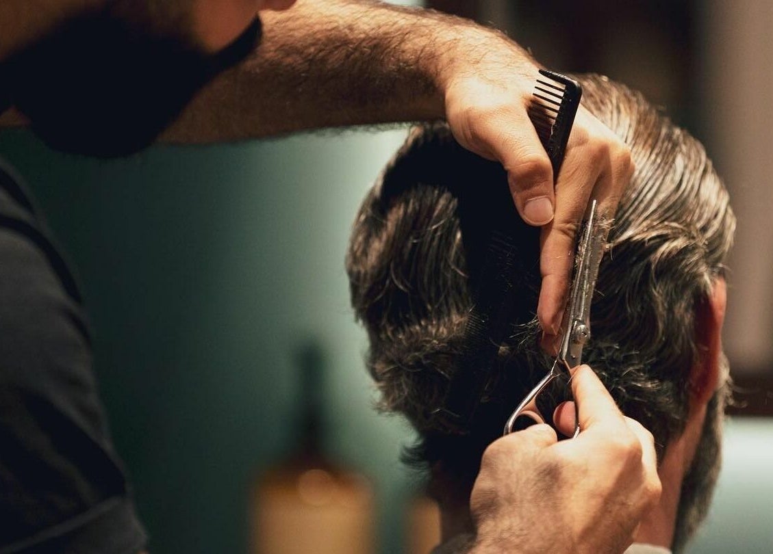 Barber crafting a precise haircut at Barber Republic Gents Saloon, Dubai, AE, showcasing expert grooming.