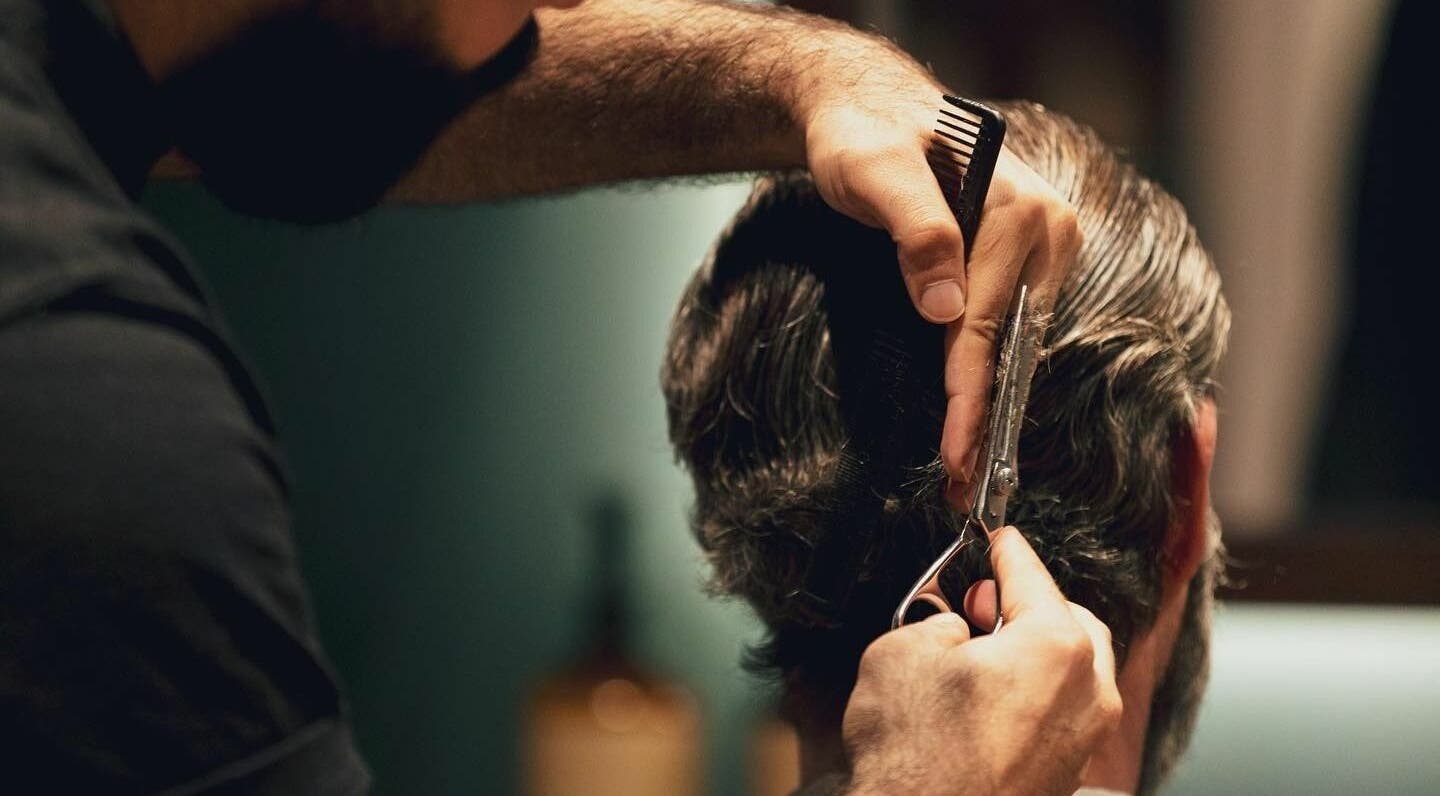 Barber crafting a precise haircut at Barber Republic Gents Saloon, Dubai, AE, showcasing expert grooming.