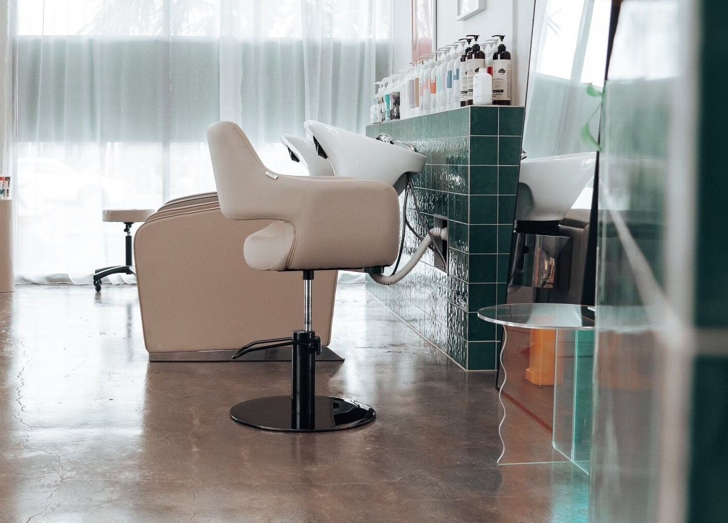 Modern salon interior at Hunny Mane Hair Artistry, Maroochydore, Queensland, AU, showcasing styling chairs and products.
