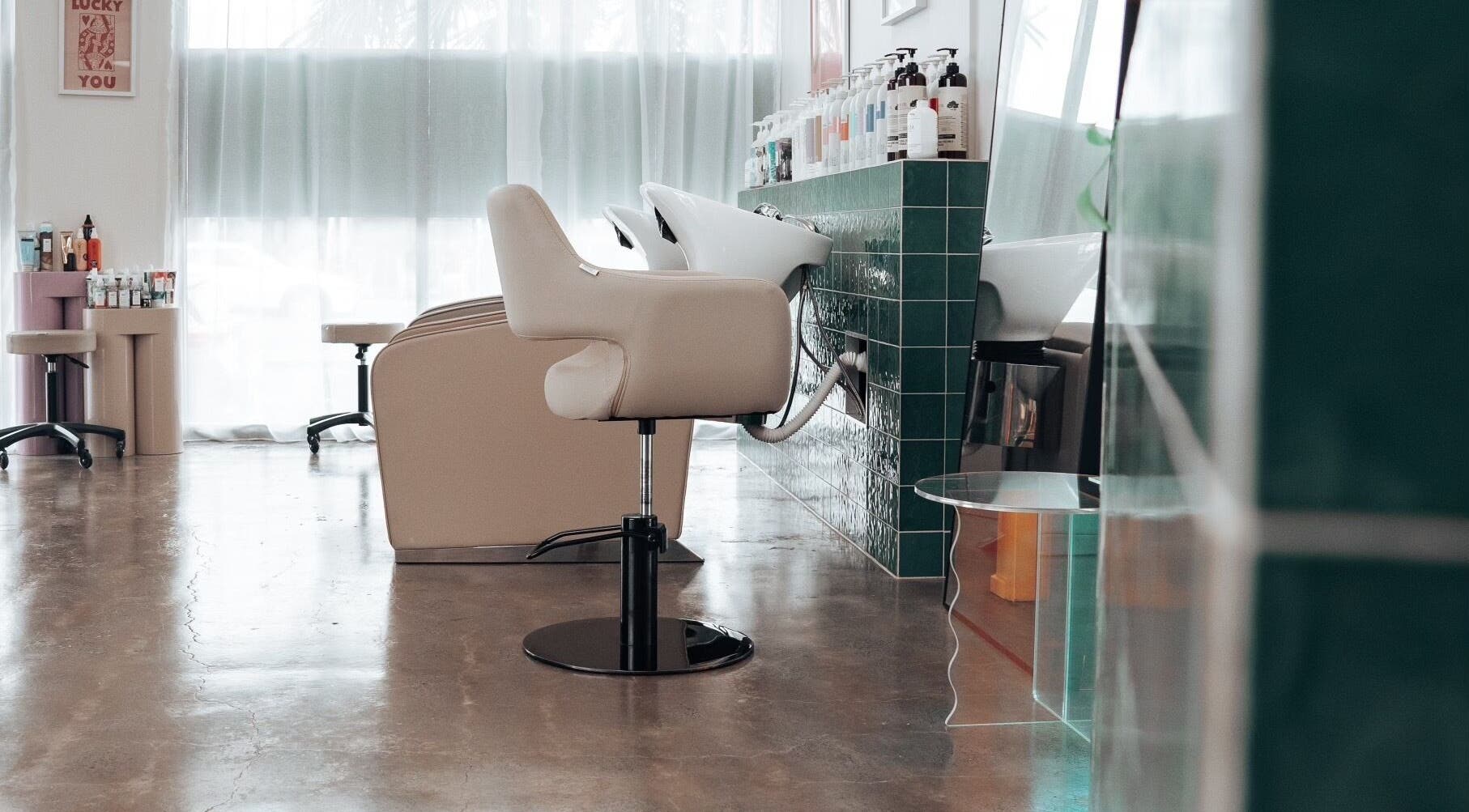 Modern salon interior at Hunny Mane Hair Artistry, Maroochydore, Queensland, AU, showcasing styling chairs and products.