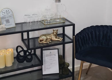 Elegant lounge area at Siren Beauty Warrnambool, Victoria, AU with plush chair and decorative shelf.