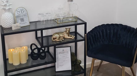 Elegant lounge area at Siren Beauty Warrnambool, Victoria, AU with plush chair and decorative shelf.