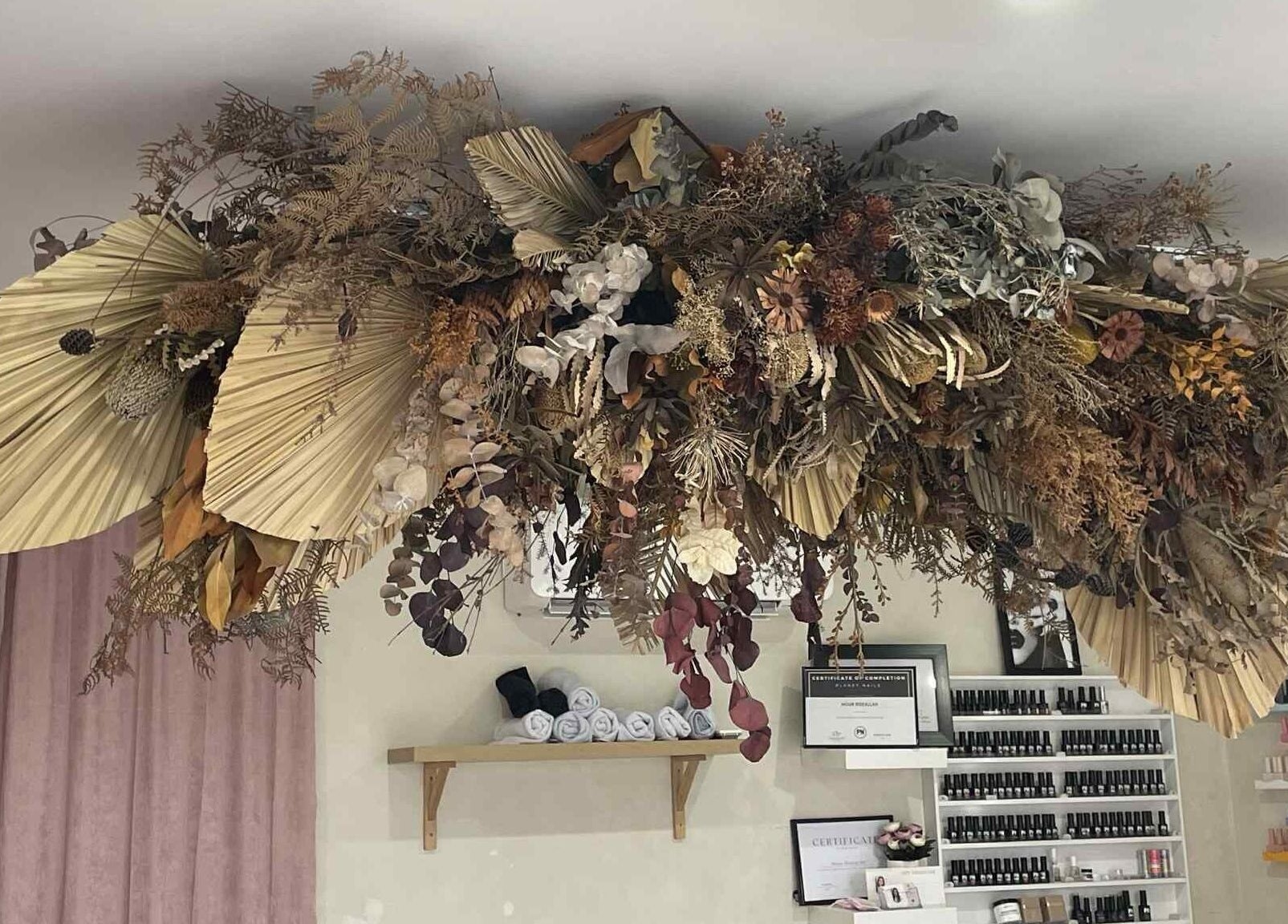 Intricate floral ceiling decor at Gelled by NR, Melbourne, Victoria, AU, enhances boutique's serene ambiance.