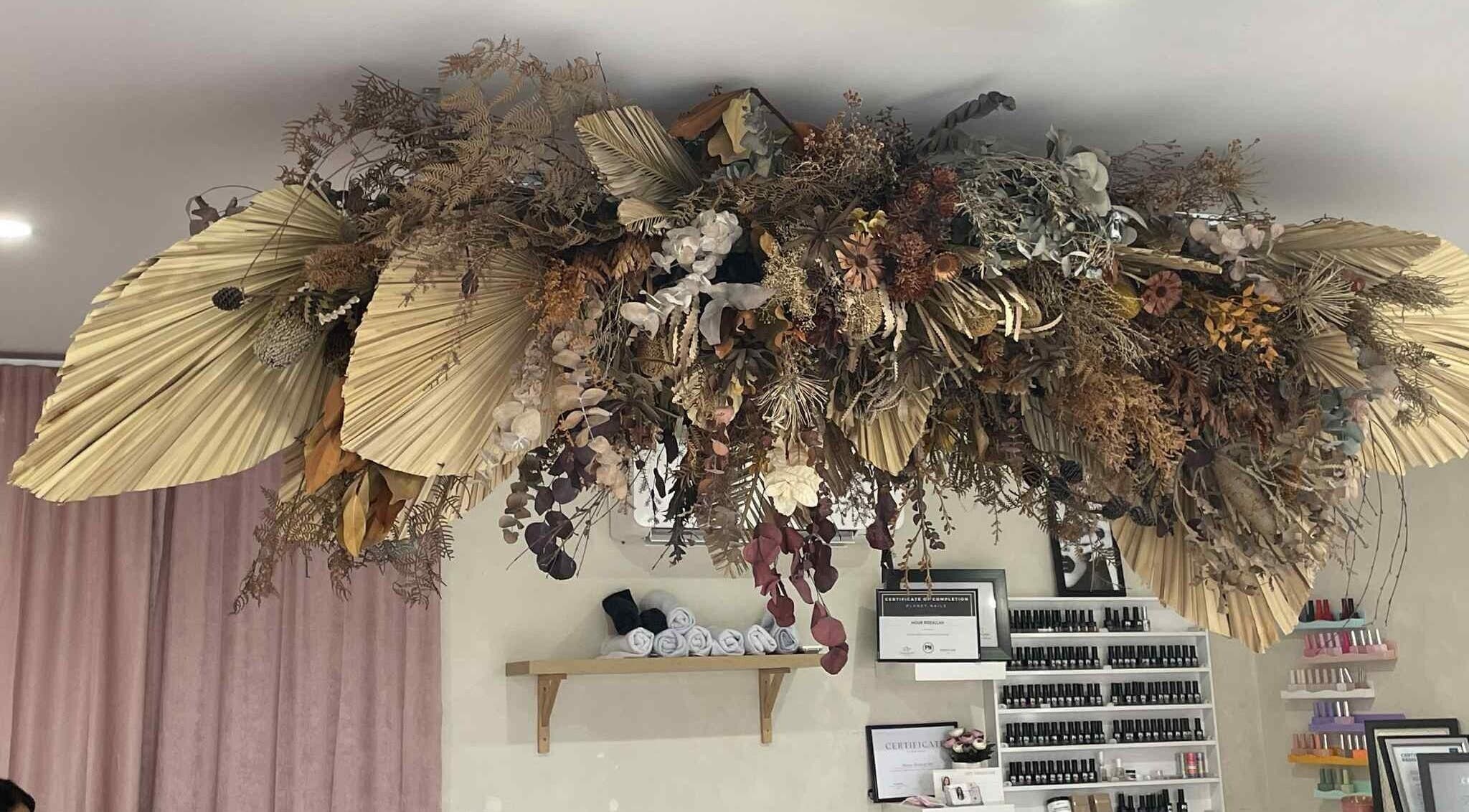 Intricate floral ceiling decor at Gelled by NR, Melbourne, Victoria, AU, enhances boutique's serene ambiance.