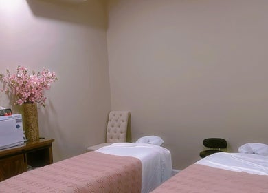 Relaxing massage room at BeYoung Massage, Tysons, Virginia, US with floral decor and twin massage beds.