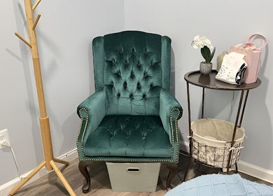 Elegant green velvet chair next to a side table at BeYoung Massage in Tysons, Virginia, US.