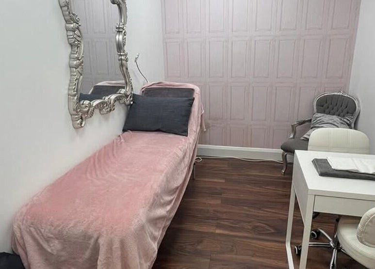 Elegant treatment room at Cherry Bomb, Frodsham, England, GB with a luxurious pink bed and ornate mirror.