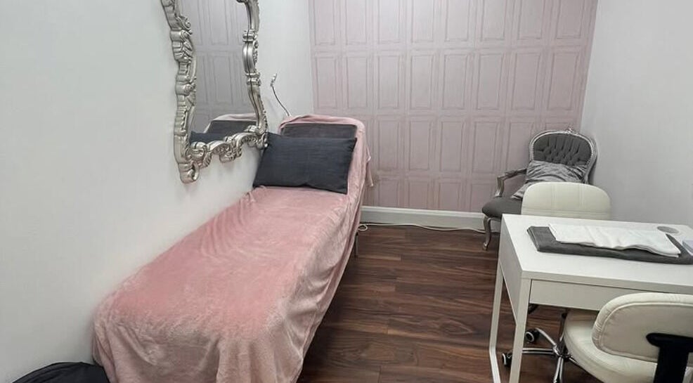 Elegant treatment room at Cherry Bomb, Frodsham, England, GB with a luxurious pink bed and ornate mirror.