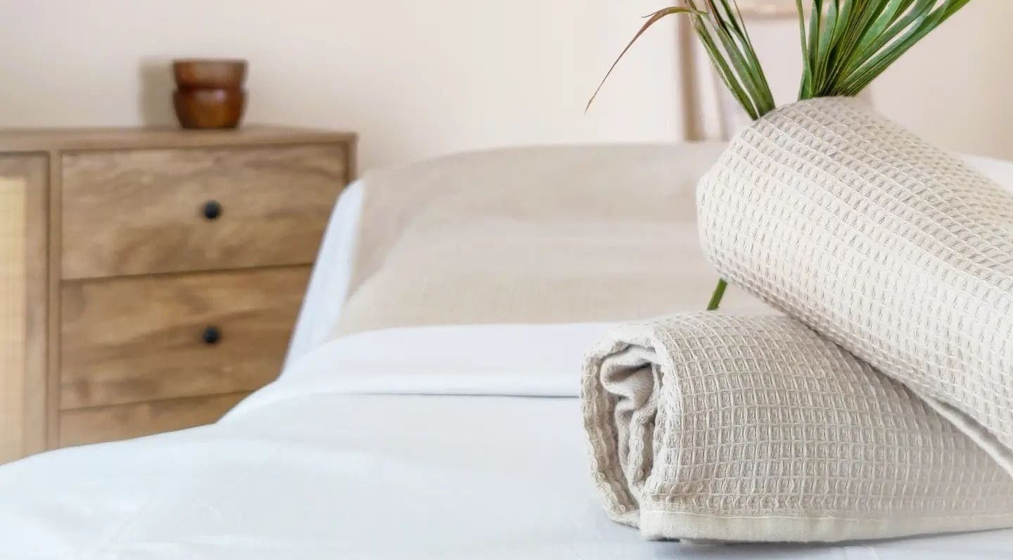 Massage bed with beige towels at Naós Massage and Wellness Studio, Kos, Greece, GR.