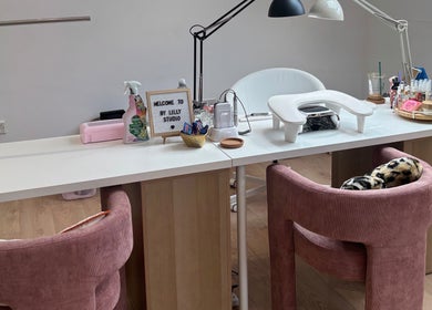 Elegant beauty studio setup at By Lilly Studio, Wilmslow, England, GB with plush pink chairs and manicure tools.