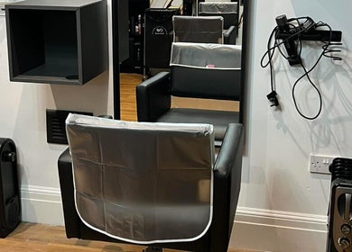 Modern salon station at Hair by Keri Muir, Larbert, Scotland, GB, featuring a stylish black chair and mirror.