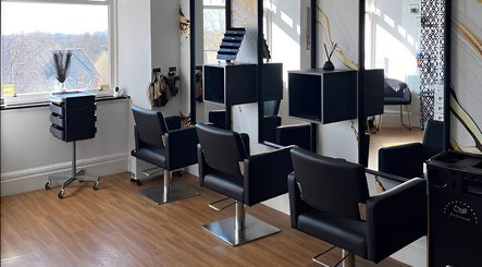 Modern salon interior at Hair by Keri Muir in Larbert, Scotland, GB featuring sleek black chairs and styling stations.
